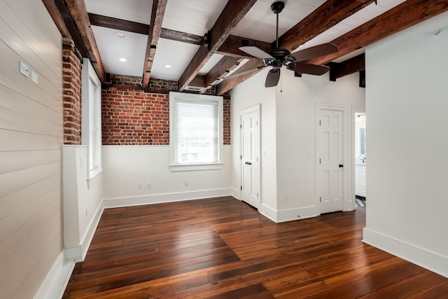 unfurnished room with beamed ceiling, brick wall, ceiling fan, and dark hardwood / wood-style floors