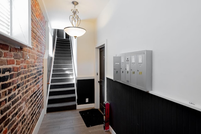 doorway to outside featuring brick wall and hardwood / wood-style floors