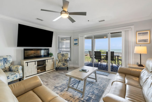 living area with visible vents, crown molding, ceiling fan, and light wood-type flooring