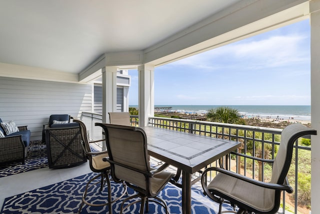 balcony with a water view and outdoor dining space