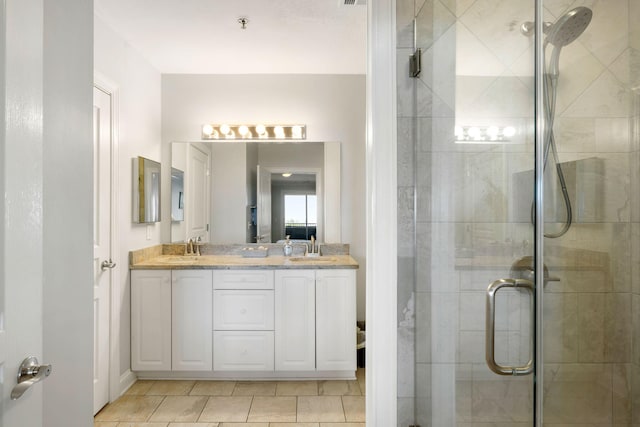 bathroom with a sink, a stall shower, and double vanity