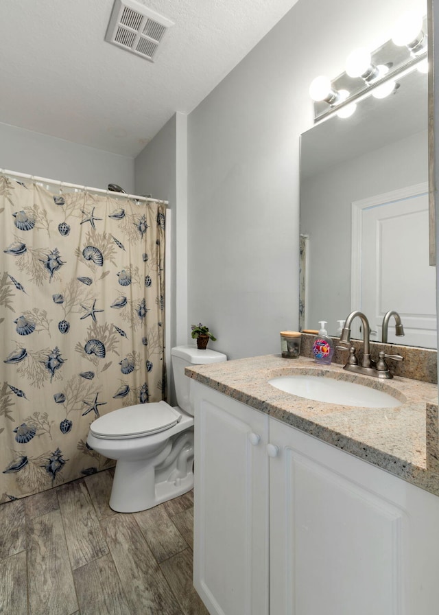 full bathroom featuring visible vents, wood finished floors, vanity, toilet, and a shower with shower curtain