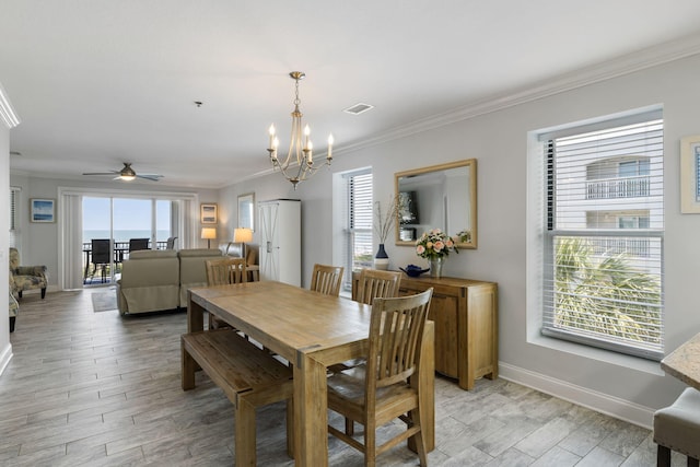 dining space featuring visible vents, light wood-style floors, crown molding, and ceiling fan with notable chandelier