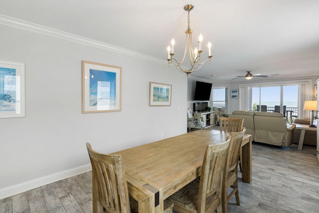 dining room with crown molding, baseboards, ceiling fan with notable chandelier, and light wood-style flooring