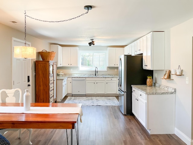 6 Littlefield St, Inman, SC 29349 - kitchen featuring white dishwasher, light wood-type flooring, a sink, freestanding refrigerator, and white cabinets