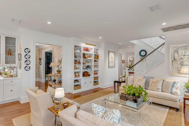 living room featuring light hardwood / wood-style flooring and crown molding