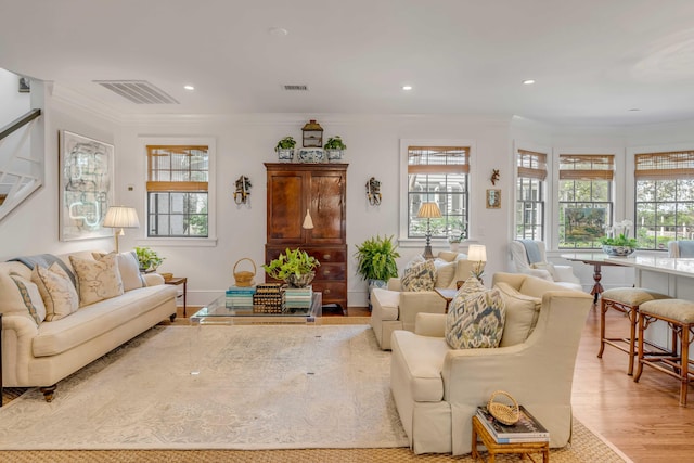 living room featuring light wood-type flooring and crown molding