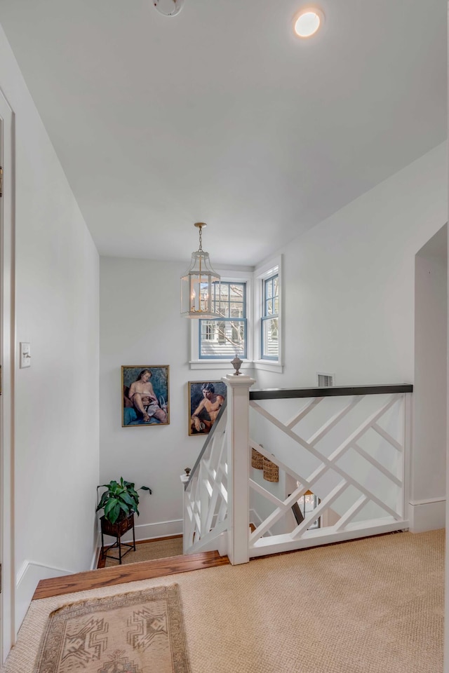 corridor featuring carpet and an inviting chandelier