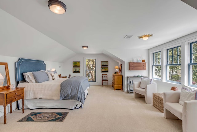 bedroom featuring multiple windows, lofted ceiling, and light carpet