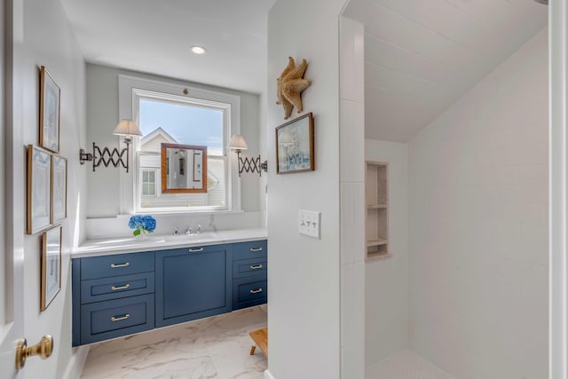 bathroom with vaulted ceiling, a shower, and vanity