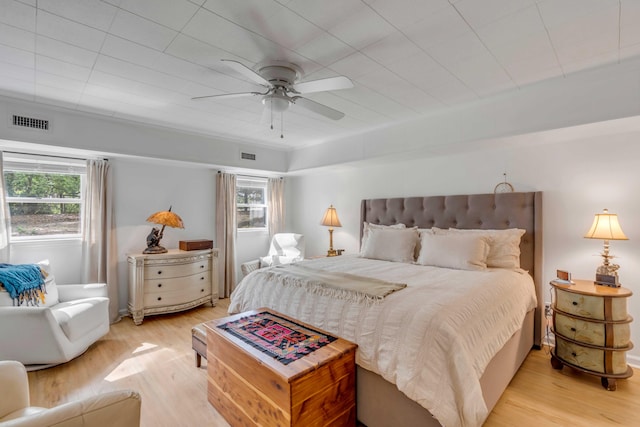 bedroom featuring multiple windows, light hardwood / wood-style floors, and ceiling fan