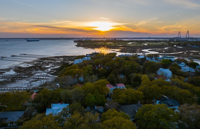 aerial view at dusk featuring a water view