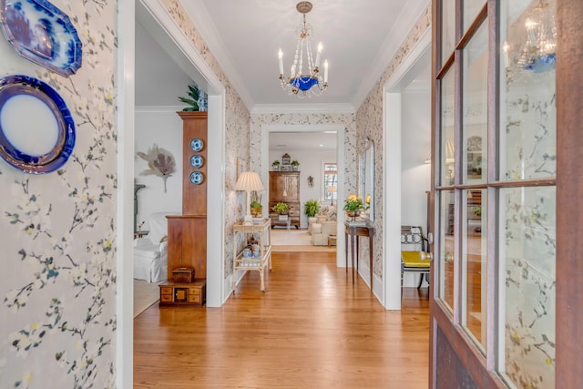 entrance foyer featuring crown molding, an inviting chandelier, and light hardwood / wood-style flooring