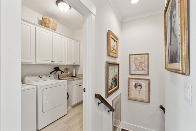 washroom with cabinet space, crown molding, light wood-type flooring, and independent washer and dryer