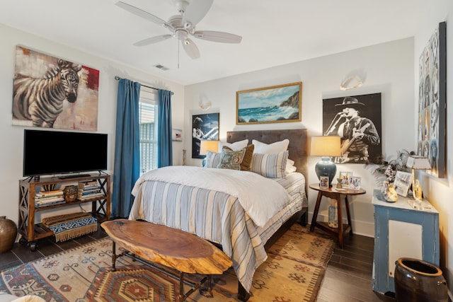 bedroom with baseboards, wood finished floors, visible vents, and ceiling fan