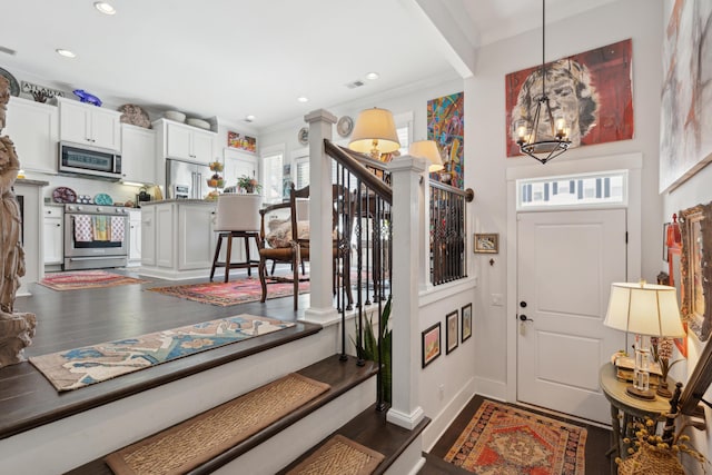 foyer entrance featuring recessed lighting, dark wood-style floors, a chandelier, and crown molding