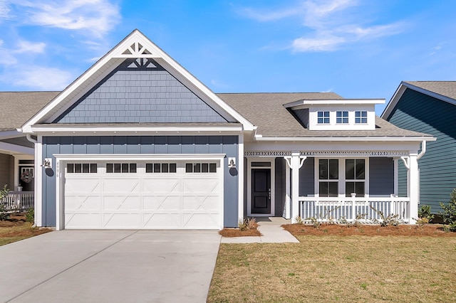 view of front facade with a garage, covered porch, and a front yard