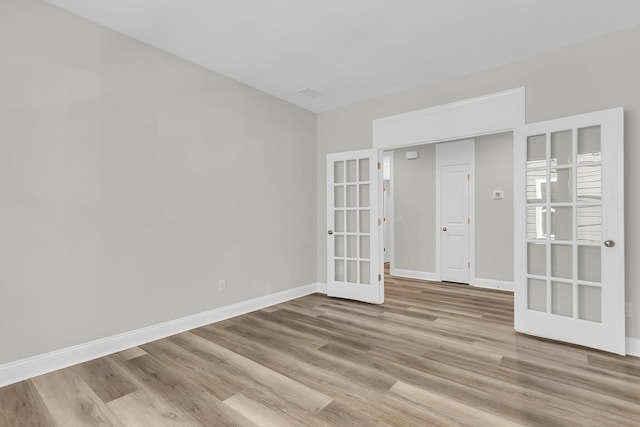 spare room with light hardwood / wood-style floors and french doors