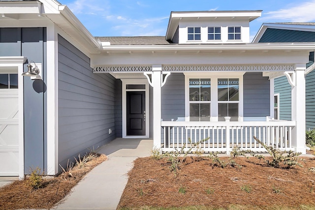 property entrance featuring a porch and a garage