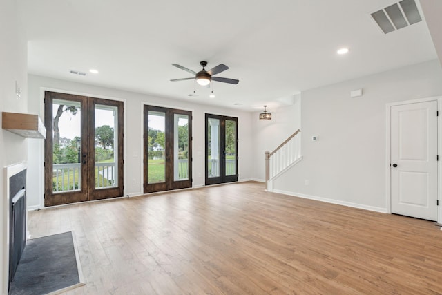 unfurnished living room with a wealth of natural light, french doors, and visible vents