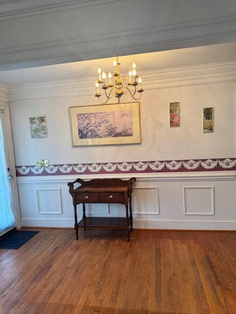1089 Charles Dr, Manning, SC 29102 - dining room featuring a chandelier, dark wood finished floors, a wainscoted wall, a decorative wall, and ornamental molding