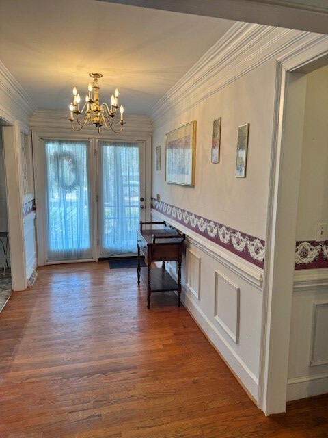 1089 Charles Dr, Manning, SC 29102 - doorway with a chandelier, crown molding, wood finished floors, a wainscoted wall, and a decorative wall