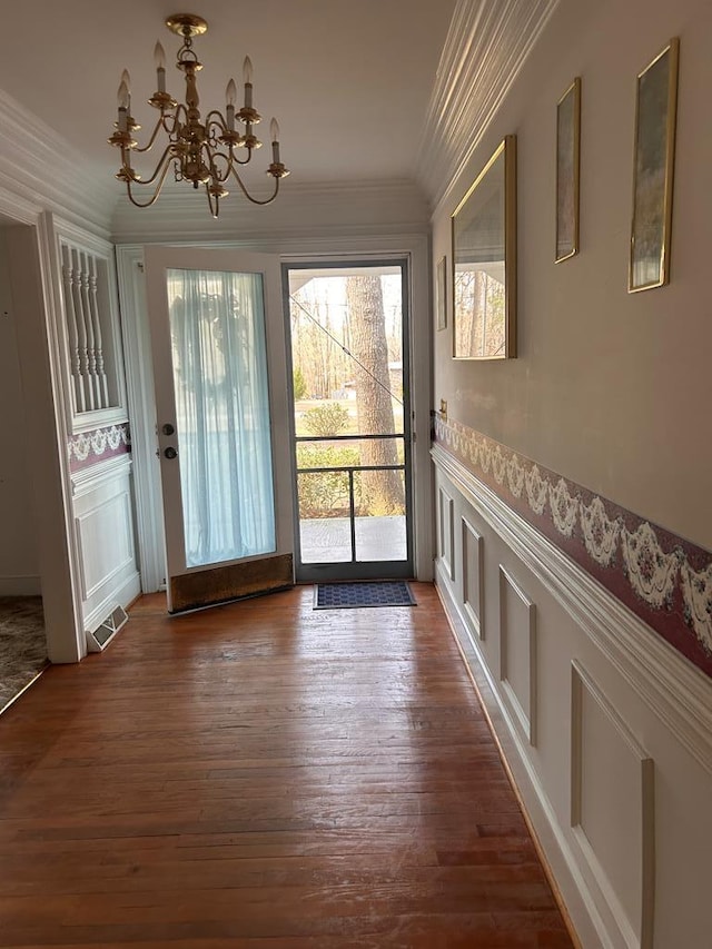 1089 Charles Dr, Manning, SC 29102 - doorway to outside featuring ornamental molding, a chandelier, dark wood-style flooring, a decorative wall, and a wainscoted wall