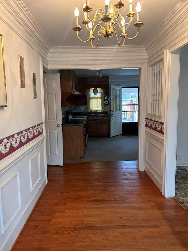 1089 Charles Dr, Manning, SC 29102 - kitchen with a chandelier, crown molding, dark countertops, a sink, and dark wood-style flooring