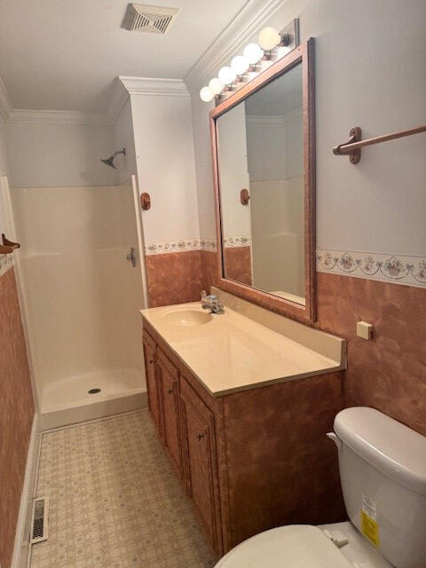 1089 Charles Dr, Manning, SC 29102 - full bathroom featuring tile walls, toilet, walk in shower, wainscoting, and vanity