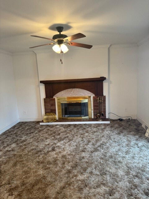 1089 Charles Dr, Manning, SC 29102 - unfurnished living room featuring a ceiling fan, a glass covered fireplace, ornamental molding, carpet flooring, and baseboards
