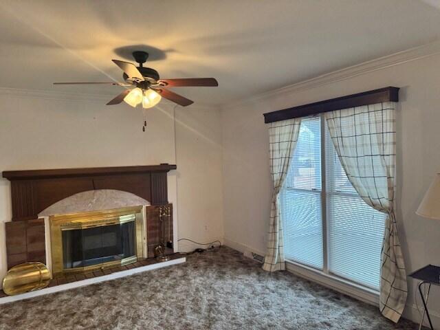 1089 Charles Dr, Manning, SC 29102 - unfurnished living room with ceiling fan, ornamental molding, a glass covered fireplace, carpet floors, and baseboards