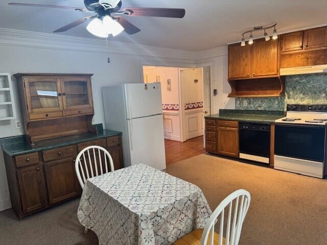 1089 Charles Dr, Manning, SC 29102 - kitchen featuring white appliances, ceiling fan, tasteful backsplash, under cabinet range hood, and glass insert cabinets
