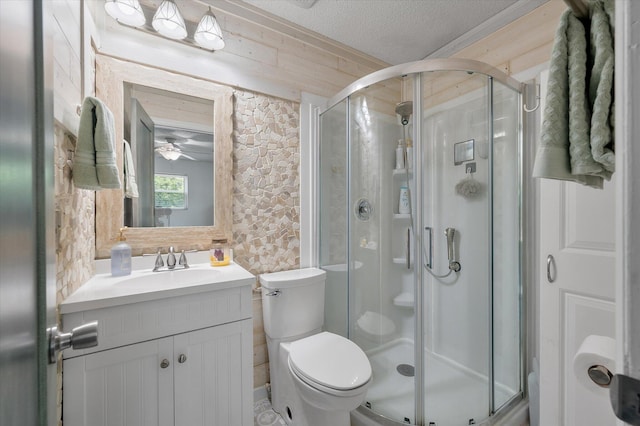 bathroom with a stall shower, toilet, a textured ceiling, vanity, and ceiling fan