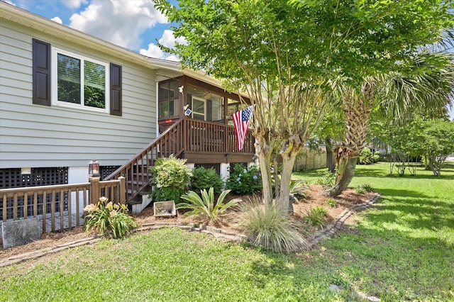 view of green lawn with stairs, a sunroom, and a deck
