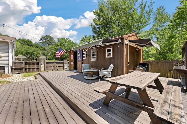 wooden deck with fence, outdoor dining space, and a gate