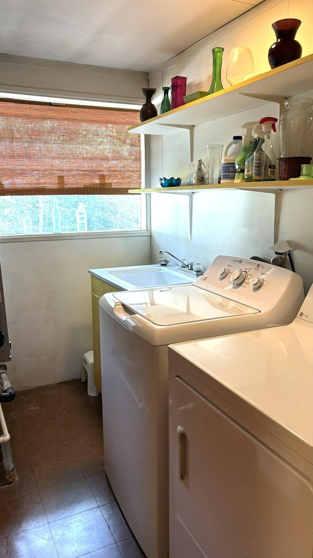 laundry room featuring sink, washer and dryer, and dark tile patterned floors