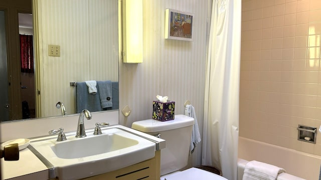 full bathroom with vanity, shower / tub combo, and toilet