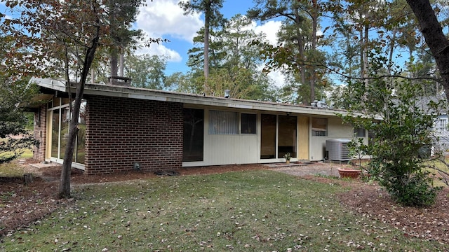 back of house featuring a yard and central air condition unit