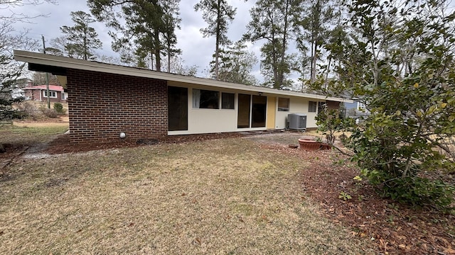 back of property featuring a yard and central air condition unit