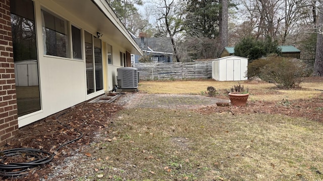 view of yard featuring a storage unit, a patio area, and central air condition unit