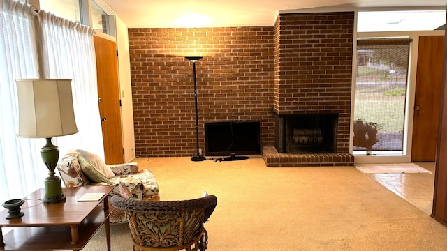 living room featuring brick wall, carpet floors, and a brick fireplace