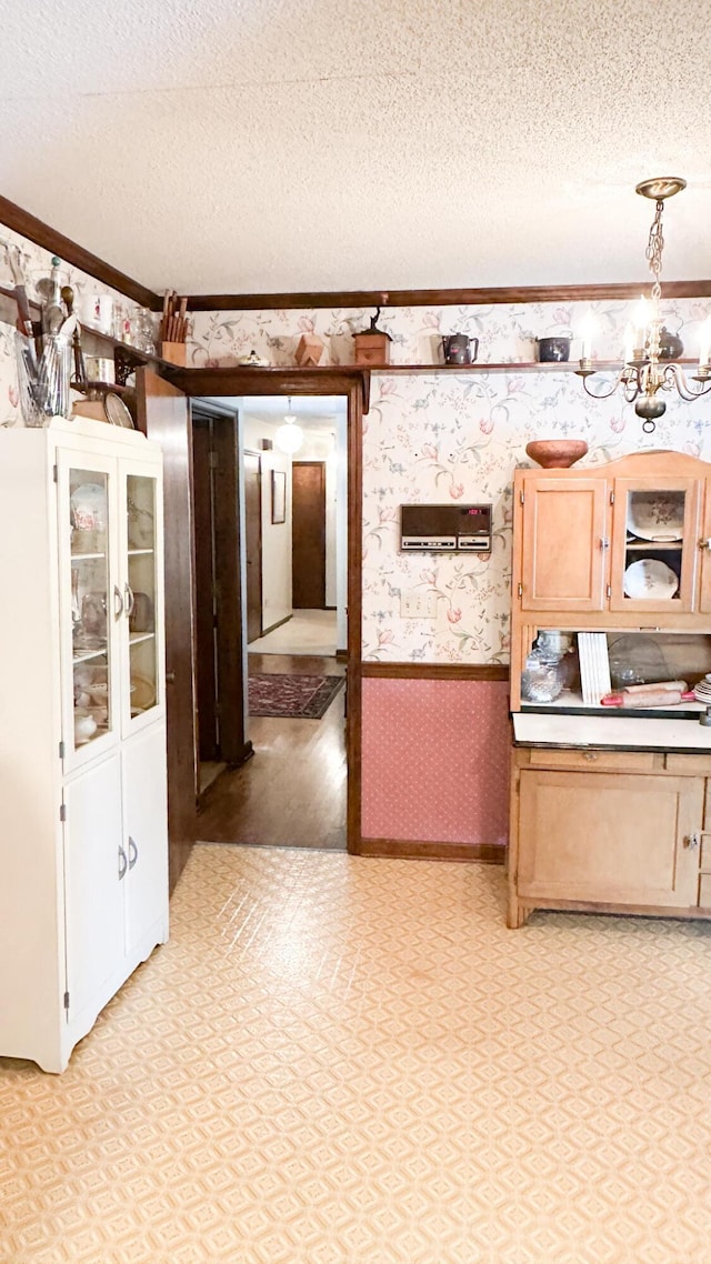 1807 Perch Rd, Moncks Corner, SC 29461 - kitchen featuring wallpapered walls, a textured ceiling, a wainscoted wall, crown molding, and a chandelier