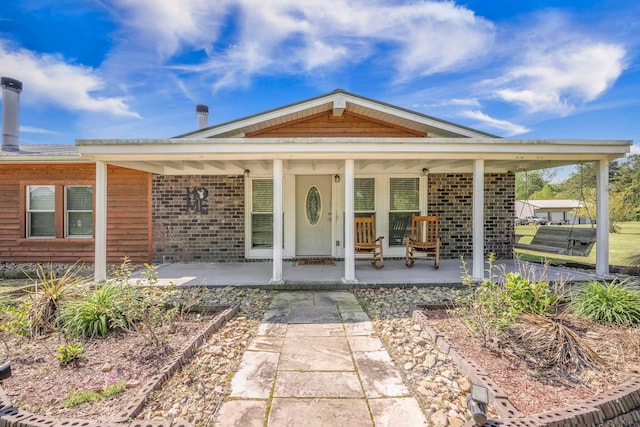 208 Mini Farm Rd, Bonneau, SC 29431 - doorway to property featuring brick siding and covered porch