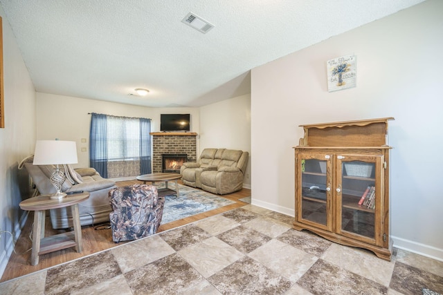 208 Mini Farm Rd, Bonneau, SC 29431 - living room with visible vents, baseboards, a brick fireplace, stone finish floor, and a textured ceiling