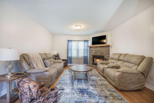 208 Mini Farm Rd, Bonneau, SC 29431 - living area featuring visible vents, baseboards, a brick fireplace, a textured ceiling, and wood finished floors
