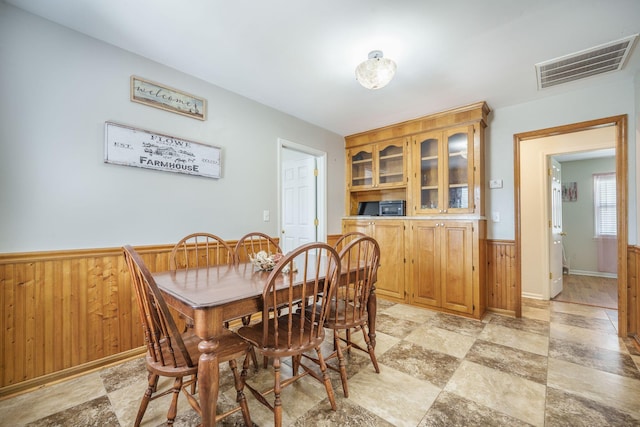 208 Mini Farm Rd, Bonneau, SC 29431 - dining area with stone finish flooring, wood walls, wainscoting, and visible vents