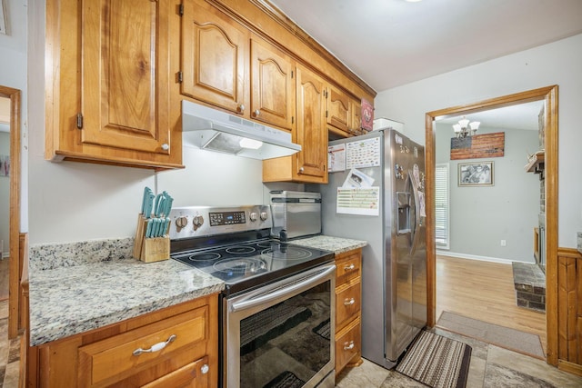 208 Mini Farm Rd, Bonneau, SC 29431 - kitchen with an inviting chandelier, brown cabinetry, under cabinet range hood, light stone counters, and stainless steel appliances