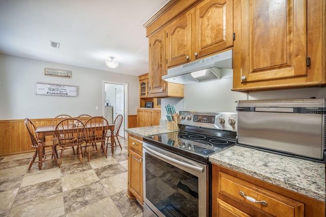 208 Mini Farm Rd, Bonneau, SC 29431 - kitchen featuring brown cabinetry, visible vents, a wainscoted wall, under cabinet range hood, and stainless steel electric range