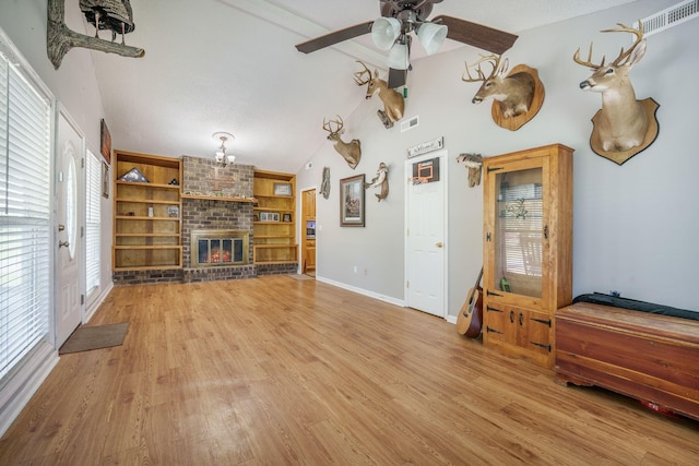 208 Mini Farm Rd, Bonneau, SC 29431 - unfurnished living room featuring vaulted ceiling, a fireplace, a ceiling fan, visible vents, and wood finished floors