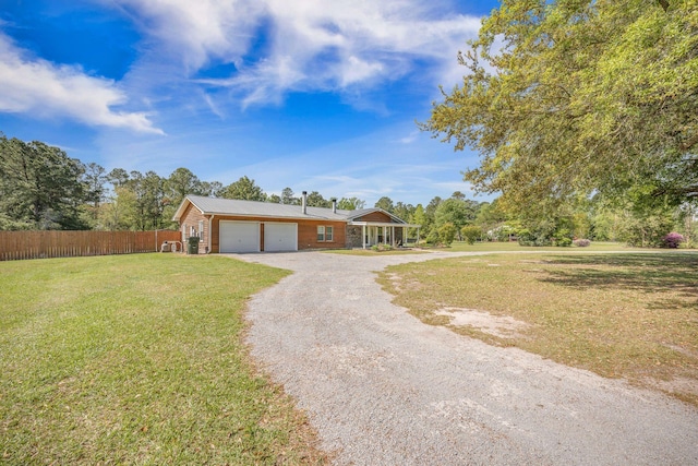 208 Mini Farm Rd, Bonneau, SC 29431 - ranch-style home with dirt driveway, an attached garage, a front yard, metal roof, and fence